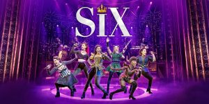 A modern office space featuring a large desk, ergonomic chair, and a computer with a city view.