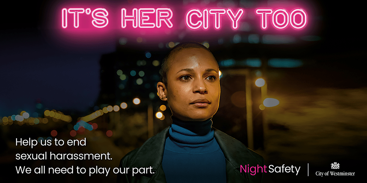 Image has 'It's Her City Too' in pink neon and a women walking through a street at night.