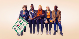 A diverse group of performers on stage, showcasing vibrant costumes and dynamic poses during a mixed bill performance.